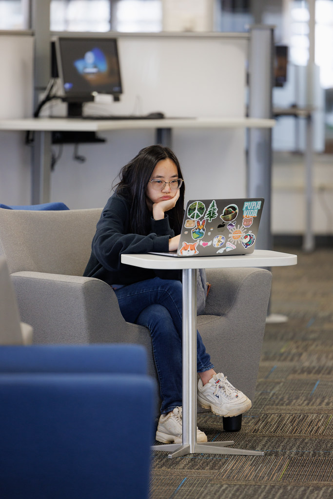 College students studying together at library tables while preparing for their final exams.