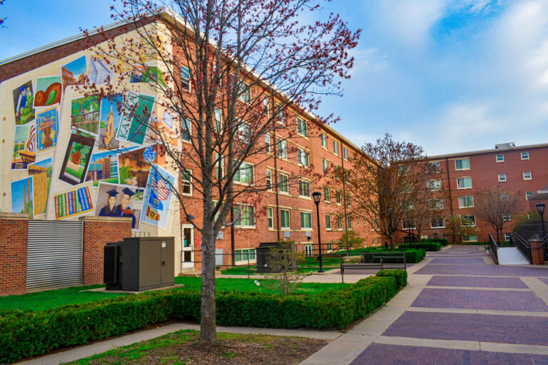 A brick residence hall and walkway on an American university campus in spring